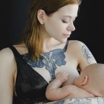 mama con tatuajes dando teta a su bebe